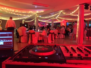 DJ-pult és keverő egy díszített lakodalmas teremben