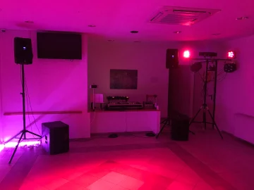Hangfalak állványon és fényeffektek egy terem sarkában